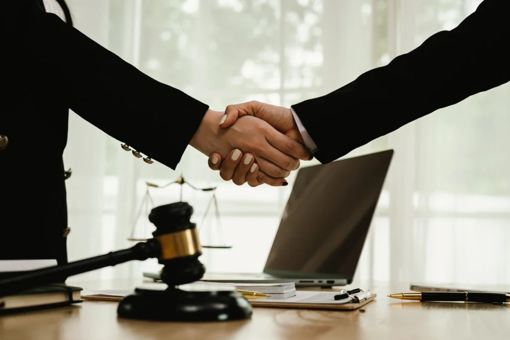 Two professionals shaking hands in a law office, symbolizing business and startup legal services.